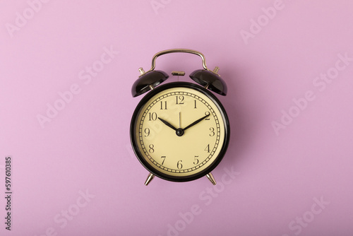 alarm clock on bright purple background.Top view.Close-up.Copy space.