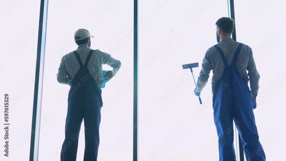 Professional cleaning team, two multiracial men washes window in office Professional cleaning team, two multiracial men washes window in office