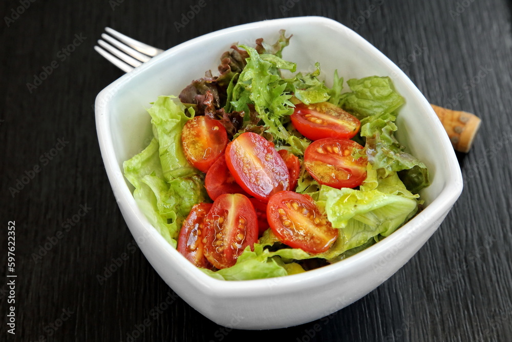 mixed leafy greens with cherry tomatoes and mustard sauce