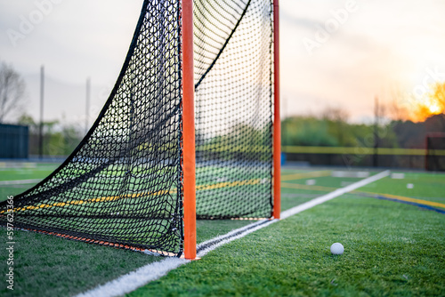 Late afternoon photo of a lacrosse goal on a synthetic turf field before a night game.
 photo