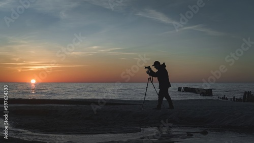 photographer with a tripod on the background of the sea near the stream
