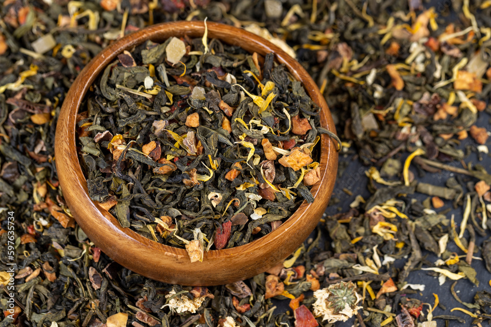 A large amount of dry green tea with pieces of fruit A large amount of dry green tea with pieces of fruit