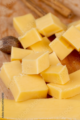 Yellow hard cheese sliced on a board