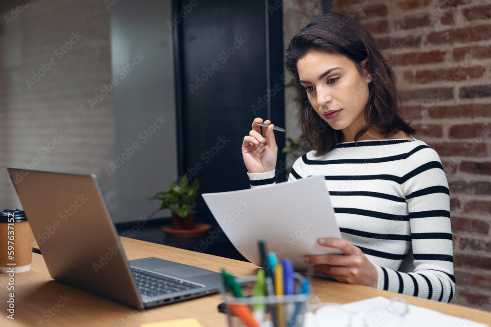 Architect engineer woman working with laptop while studying the blueprints in a modern office. Architect engineer woman working with laptop while studying the blueprints in a modern office.