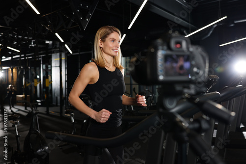 Fitness trainer recording online classes in gym