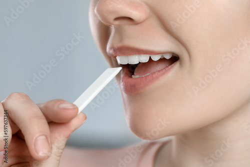 Woman with chewing gum on blurred background  closeup