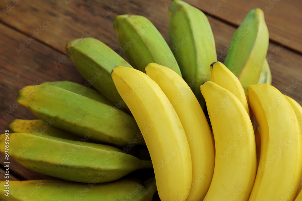 Bunches of tasty bananas on wooden table, closeup