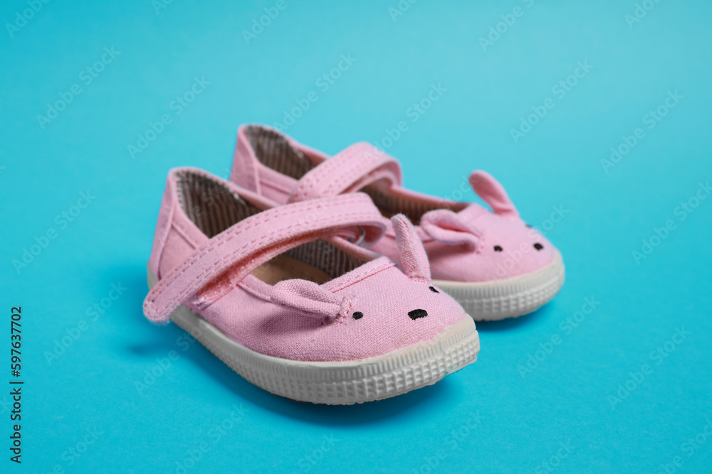 Pair of cute baby shoes on light blue background Pair of cute baby shoes on light blue background