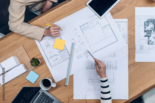 Hands of architects working with blueprints of their new design business in the office. photo