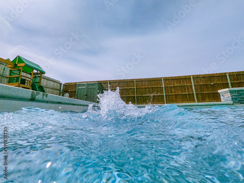 Obraz na płótnie A serene photo capturing the perfect summer day with a vibrant swimming pool as the main focus, charmingly accompanied by a delightful duck enjoying a cool swim. A must-see for all nature and aquatic w salonie