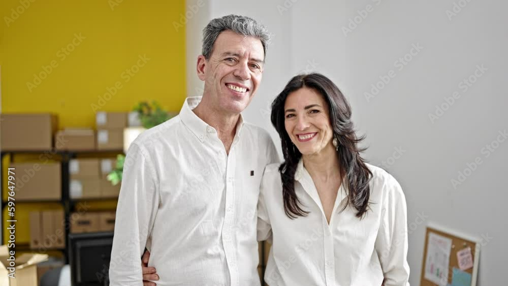 Senior man and woman ecommerce business workers hugging each other at office Senior man and woman ecommerce business workers hugging each other at office