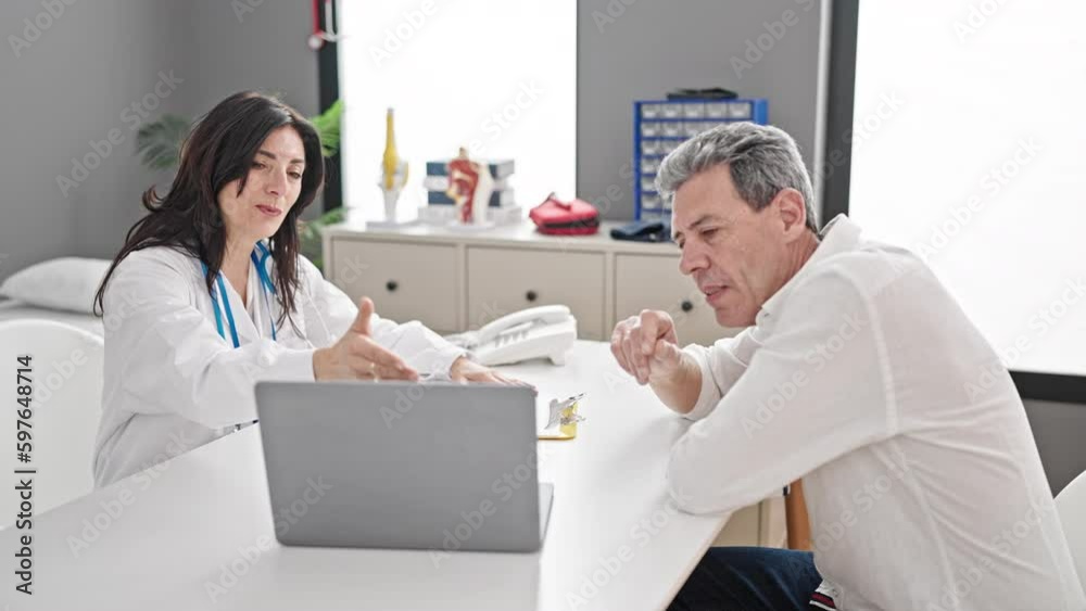 Senior man and woman doctor and patient having medical consultation looking laptop at clinic Senior man and woman doctor and patient having medical consultation looking laptop at clinic