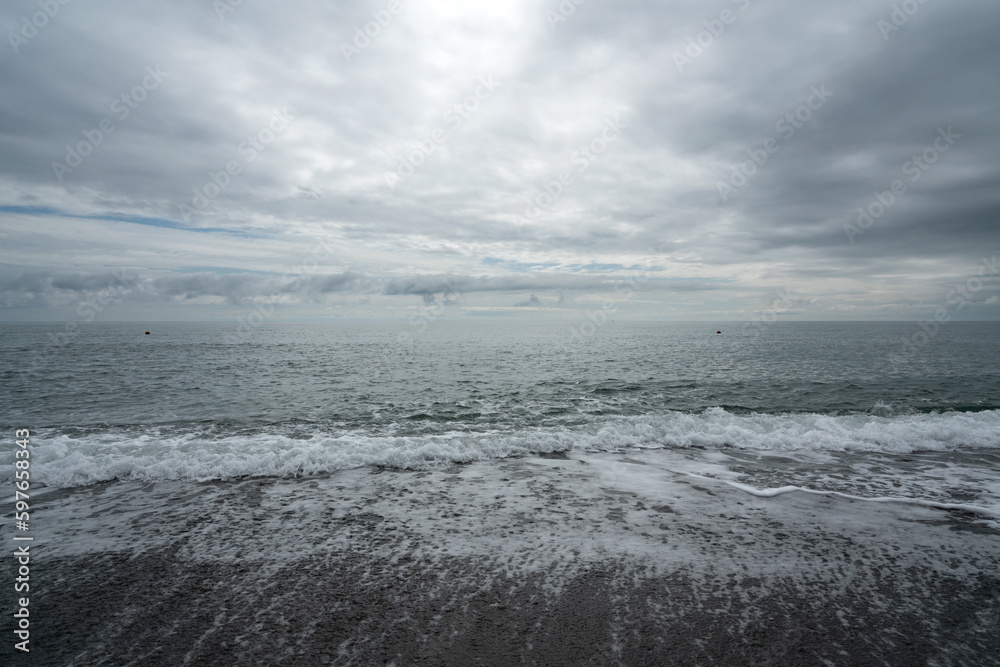 Black Sea on the Sochi coast and a pebble beach on a sunny day with clouds, Sochi, Krasnodar Territory, Russia Black Sea on the Sochi coast and a pebble beach on a sunny day with clouds, Sochi, Krasnodar Territory, Russia