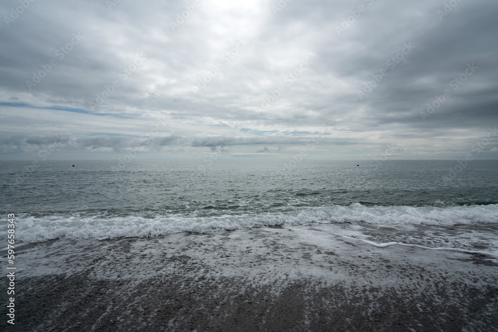 Black Sea on the Sochi coast and a pebble beach on a sunny day with clouds, Sochi, Krasnodar Territory, Russia