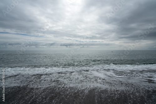 Black Sea on the Sochi coast and a pebble beach on a sunny day with clouds  Sochi  Krasnodar Territory  Russia