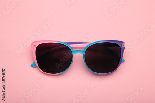 Colorful sunglasses on pink background. Top view