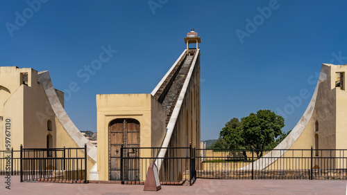 The world's largest sundial Samrat Yantra in the ancient observatory of Jantar Mantar. A high staircase with a pavilion at the top, a curved marble measuring surface is visible. Blue sky.India. Jaipur photo