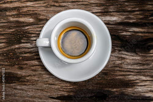 Two white cups of espresso on wooden background.