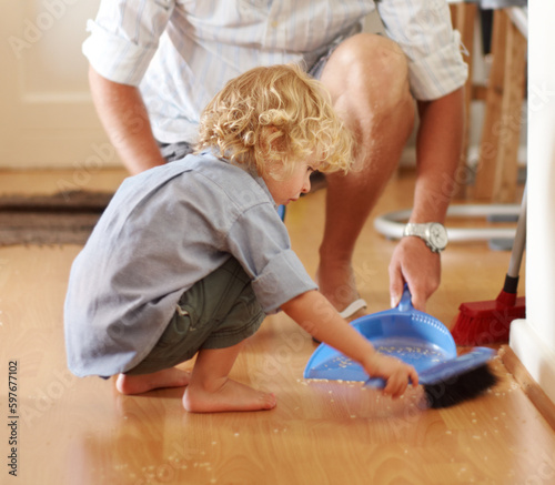 фотографія Father with boy child sweeping up mess, family cleaning together and help with broom and dustpan