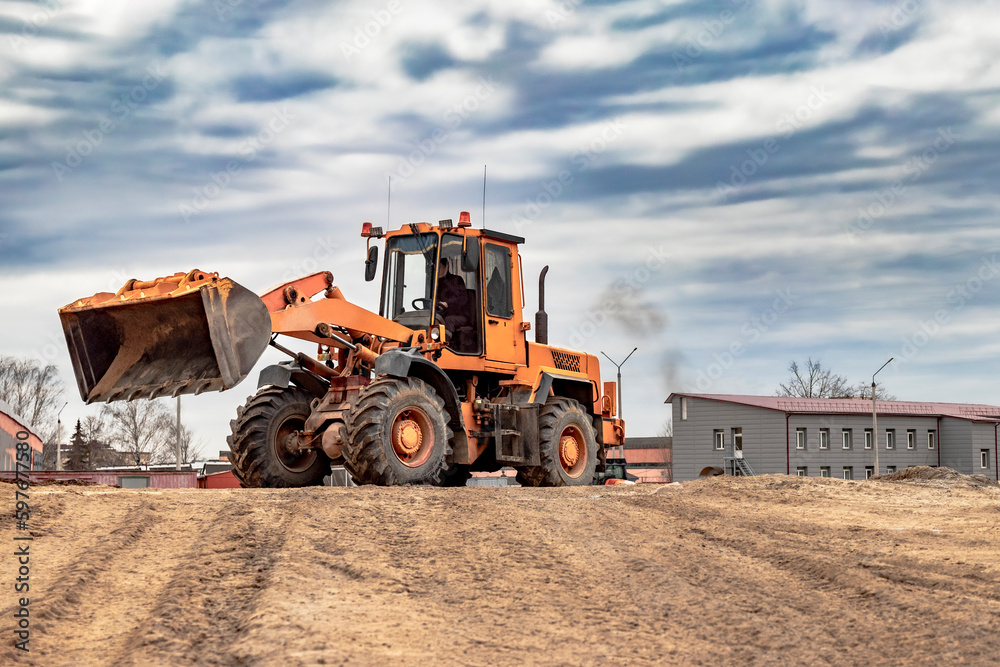 Powerful wheel loader or bulldozer working on a quarry or construction site. Close-up of earthworks. Powerful modern equipment for earthworks. Powerful wheel loader or bulldozer working on a quarry or construction site. Close-up of earthworks. Powerful modern equipment for earthworks.