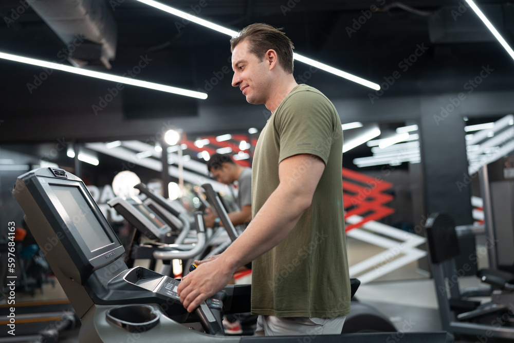 Caucasian man with exercise machine at fitness gym Caucasian man with exercise machine at fitness gym
