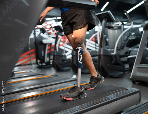 Low angle view at woman with prosthetic leg walking in treadmill at fitness gym  © chachamp