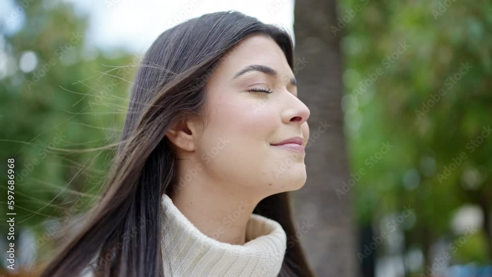 Young beautiful hispanic woman breathing with closed eyes at park Young beautiful hispanic woman breathing with closed eyes at park