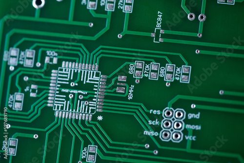 Macro shot of the back side of a circuit board. Close up of a printed green computer circuit board