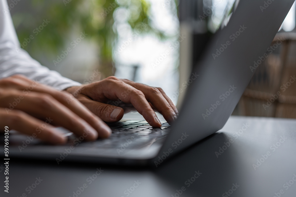 Businessman typing on the laptop keyboard closeup with blurred background - obrazy, fototapety, plakaty 
