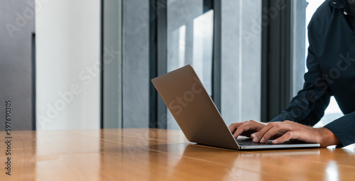 Man in blue shirt typing on laptop