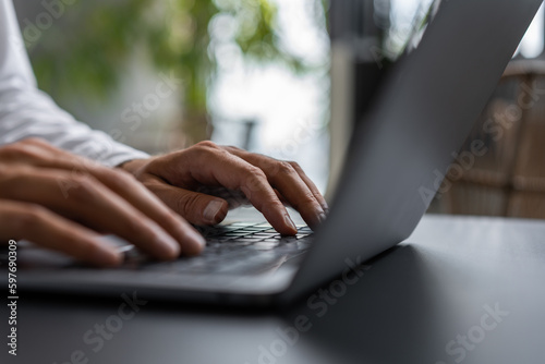 Obraz na plátne Businessman typing on the laptop keyboard closeup with blurred background