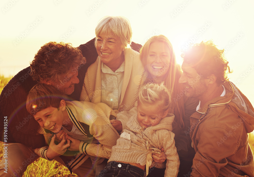 Happy, love and big family in nature at sunset hugging, bonding and spending quality time together. Happiness, smile and children posing with their parents and grandparents in outdoor field at dusk.