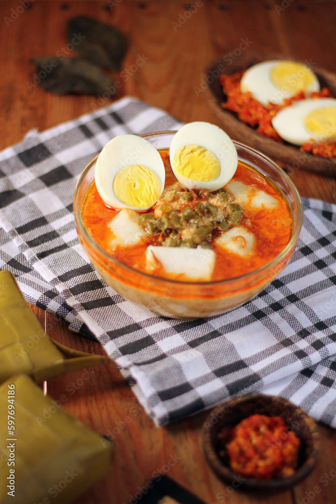 A plate of Indonesian traditional food including a bowl of soup Lontong Sayur