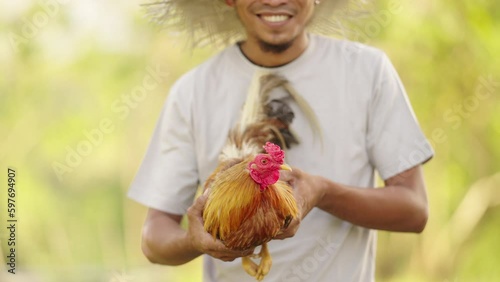 Proud Southeast Asian Man Smiles with Fighting Cock, portrait, culture heritage photo
