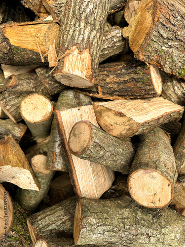 Cut pieces of wood. A large pile of firewood. Trees has been cut and split into firewood to be used as fuel for heating in fireplaces and furnaces in the. Close up