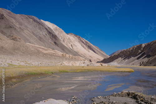 grassland, small river and mountain, blue sky at Ladakh, India
