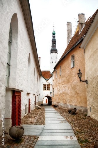 The Narrow Alley of Borsi Kaik in the Beautiful Old City of Tallinn, Estonia with the Tower of the Holy Spirit Church photo