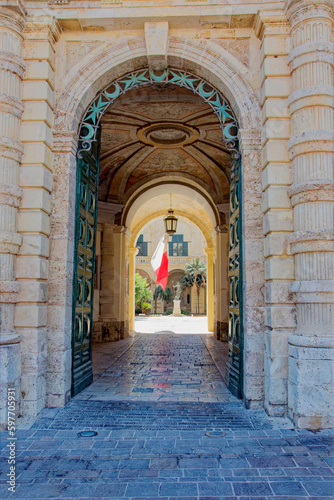 Arch at entrance of Grandmaster's Palace with with maltesian flag in the background r on a sunny hot summer day. Photo taken August 9th, 2017, Valletta, Malta. © Michael Derrer Fuchs