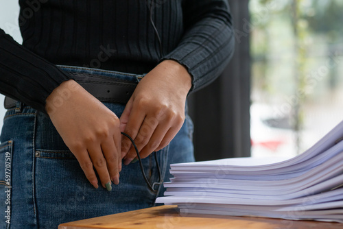 Businesswoman hands working on stacks of paper documents to search and review documents piled on table before sending them to board of directors to use correct documents in meeting with Businessman