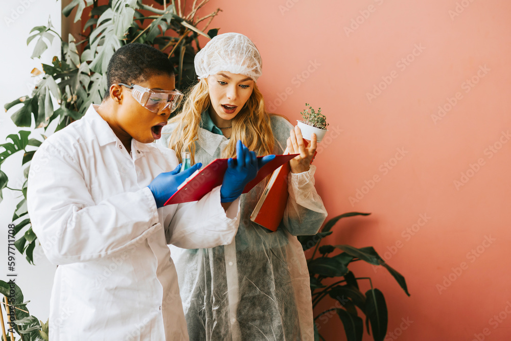 african american and caucasian woman student with conducts an experiment with beaker and liquid in protective glasses, studies viruses and bacteria, scientist doctor of biology with scientific project