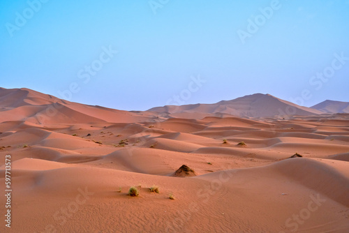 Fototapeta Naklejka Na Ścianę i Meble -  A landscape shot of the sand dunes in the Sahara desert, Morocco, on a clear blue sky day. 