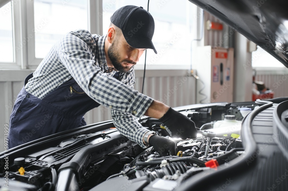 Handsome Car Mechanic is Posing in a Car Service. Handsome Car Mechanic is Posing in a Car Service.