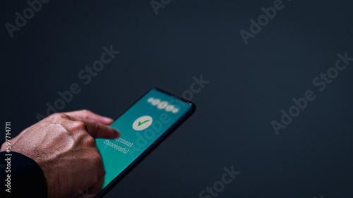 Obraz na plátně Businessman hand holds a smartphone on screen with message payment successful Concept