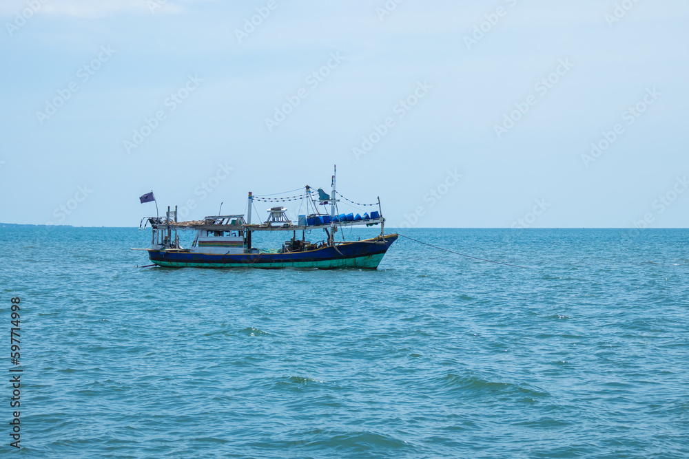 Small fishing boat sailing in a open sea. Fishing boat floating on the water, blue sea.