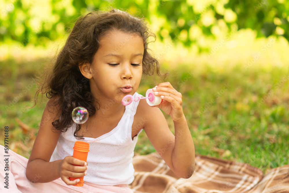 happy mixed race girl with soap bubbles,portrait of a child in the park happy mixed race girl with soap bubbles,portrait of a child in the park