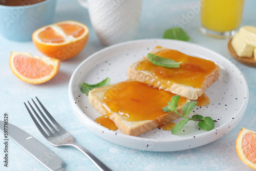 Sandwiches with marmalade, orange juice and coffee ready for breakfast
