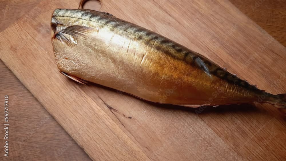 Whole cold-smoked Atlantic mackerel without head on cutting board Whole cold-smoked Atlantic mackerel without head on cutting board