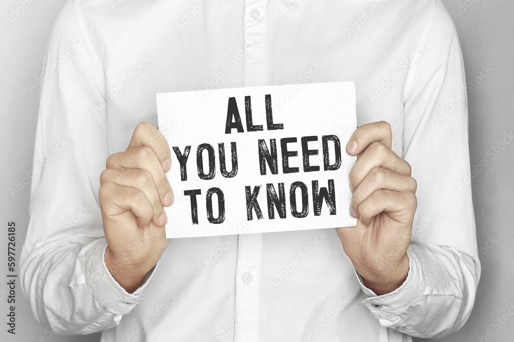Man holding a paper card with text All you need to know Man holding a paper card with text All you need to know
