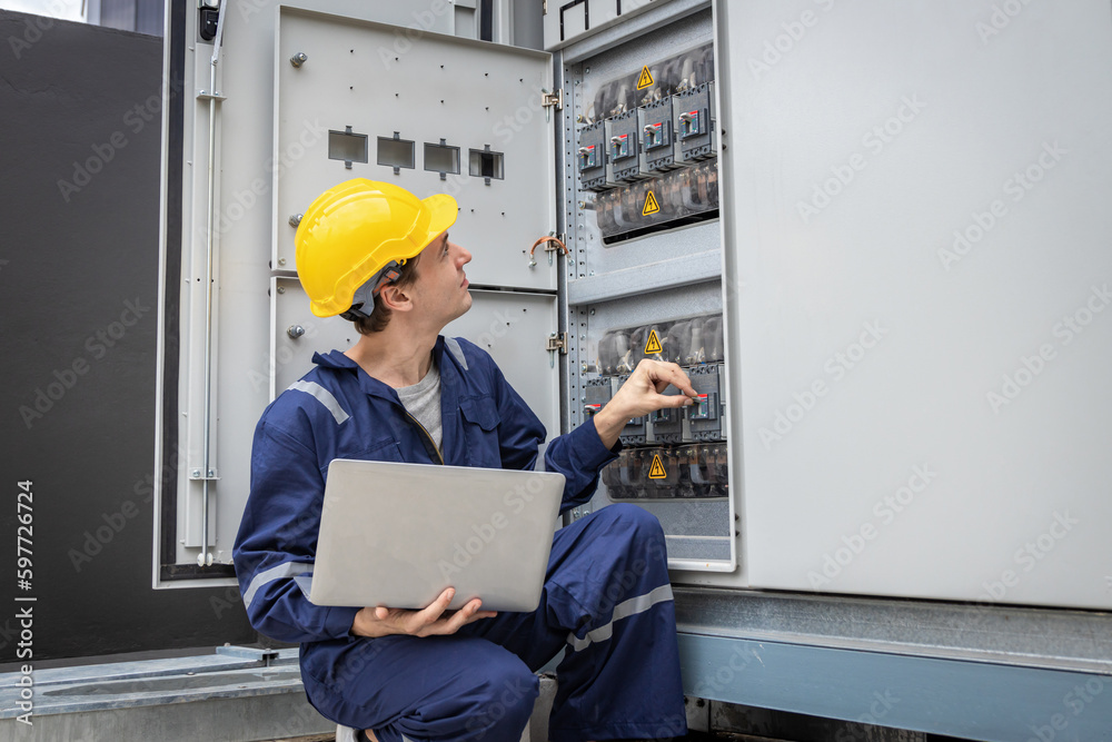 Electrical engineer working in control room. Electrical engineer man checking Power Distribution Cabinet in the control room Electrical engineer working in control room. Electrical engineer man checking Power Distribution Cabinet in the control room