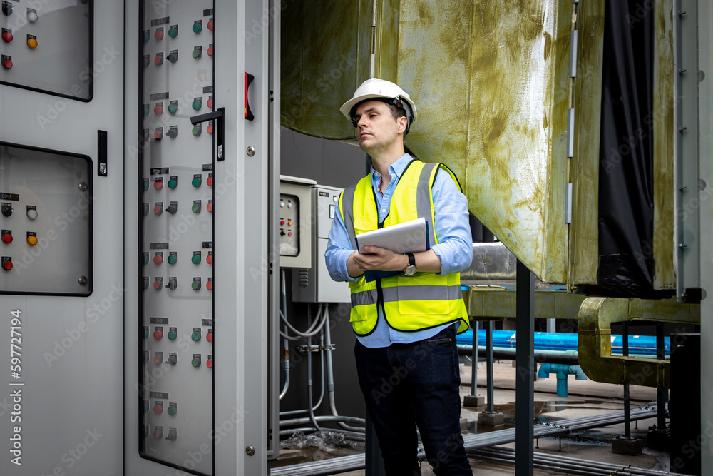 Electrical engineer working in control room. Electrical engineer man checking Power Distribution Cabinet in the control room Electrical engineer working in control room. Electrical engineer man checking Power Distribution Cabinet in the control room